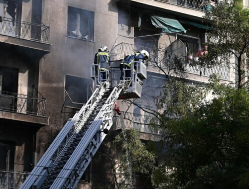 Πυροσβέστες σε κλιμακοφόρο όχημα επιχειρούν σε πολυκατοικία με σοβαρές ζημιές από αστική πυρκαγιά
